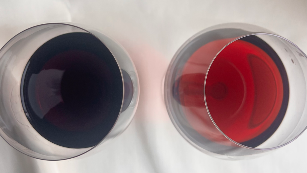 Two glasses of red wine viewed from above showing differences in color intensity.